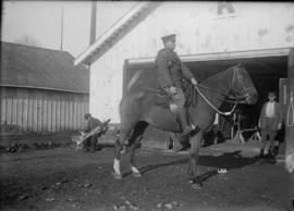 [Mounted soldier in front of a barn]