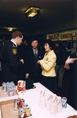 [Wendy Au] talking with two unidentified men at International Day to End Discrimination reception
