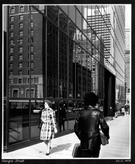 [People walking down] Georgia Street [Devonshire Hotel reflection in building windows]