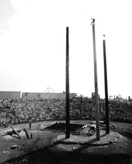 Man balancing at the top of log climbing log at P.N.E. Festival of Logging