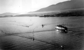 A ship and several small boats in First Narrows