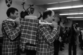 Michael Francis and Mike Harcourt dressed in Centennial tartan carrying the haggis