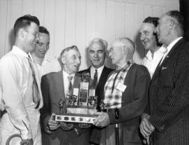 Judge and P.N.E. official pose with trophy winning swine breeders in 1962 P.N.E. Livestock compet...