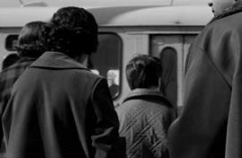 [View of passengers standing outside bus doors]