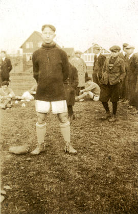 [Chinese Students' Athletic Association soccer team member standing in a field]