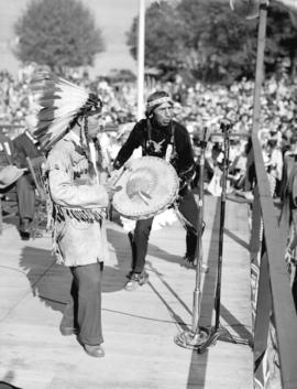 [August Jack Khatsahlano and another man playing music at the rededication of Stanley Park]