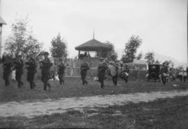 Pipe Band marching down unpaved street