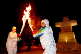 Day 75 Torchbearer 102 Dwain Krissa (R) passes the flame to Torchbearer 103 Rowena Epp (L) in fro...