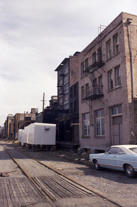 [View of downtown street with buildings and train tracks, 1 of 2]