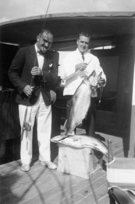 A man showing off his catch while Webber holds the fish