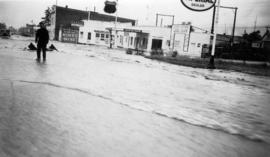 Man in flooded street in front of Union Oil Dealer