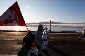 NEW-Day 33 Torchbearer 18a Patrick Tremblay carrying the flame in Ragueneau, Quebec