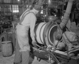 Worker operating a machine with a barrel