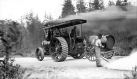 [Two unidentified men operating steam traction engine with lettering 'Government of British Colum...