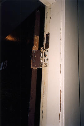 Damaged door hinge inside Columbia Hotel at 303 Columbia Street