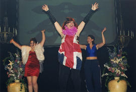 Three women in costumes dancing on stage