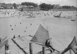 English Bay - view of beach and buildings from pier with sailboat docked