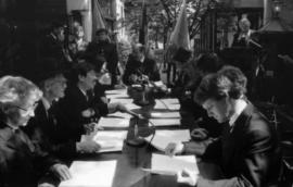 Group of actors seated at table for re-enactment