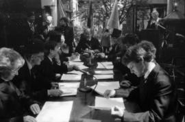 Group of actors seated at table for re-enactment