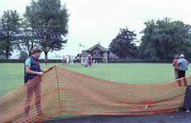 Unidentified man installing orange fencing