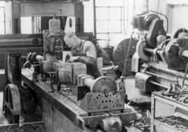 Machinist Gordon Lewis working on a crankshaft for a Victory ship at the refinery in WW II [World...