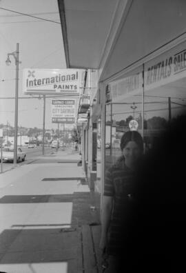[Pedestrians outside of International Paints and Vancouver City Loans at 3283-3295 West Broadway]