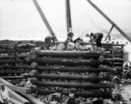 Building rock-filled cribbing at water's edge on South Shore which are foundations for derricks. ...