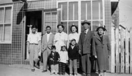 Guy, Vernon, and Gum May Yee with a group of people in front of Gordon Yee's café in Naicam, Sask...