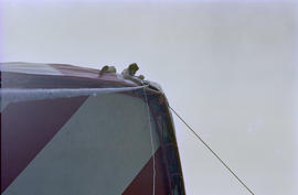 Man attaching canopy to top of stage structure