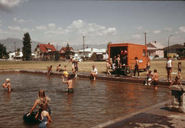 [People climbing out of truck next to people in wading pool]