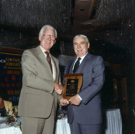 Robert Gordon Rogers delivering plaque to man at Kiwanis Club Centennial luncheon