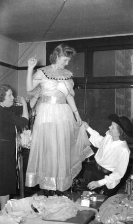 [Woman having dress fitted for the Rotary Ice Carnival]