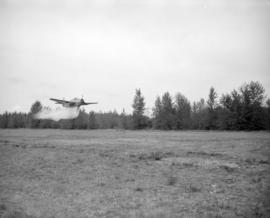 [Water bomber dropping water on a field in Abbotsford]
