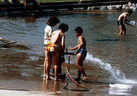 [People playing in water from fire hydrant]