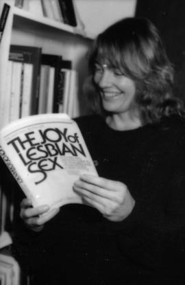 Woman holds book 'The Joy of Lesbian Sex'