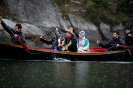 Skwxwú7mesh man carries the lantern in a canoe in Squamish, BC