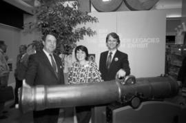 Unidentified man and woman with Gordon Campbell beside canon at Legacies event at The Bay