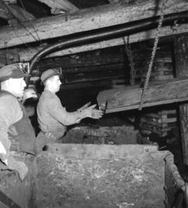 [Miners at work in a shaft]