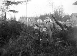 Three unidentified children standing in brush