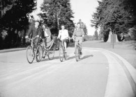 [Four cyclists near entrance to Stanley Park]