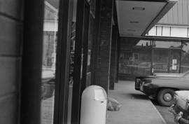 [View of storefronts and parked vehicles]