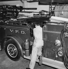[Mechanic Walt Huntley working on fire engine at machine shop]