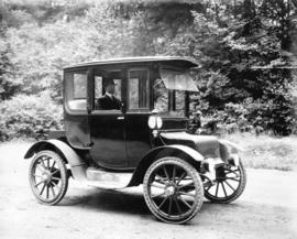 [Man seated in electrically operated coupe style car]