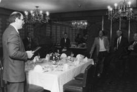 Mike Harcourt holds award for Peter Paul Saunders in banquet room