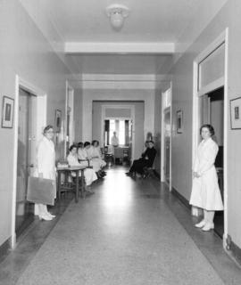 [Nurses and patients in hallway]