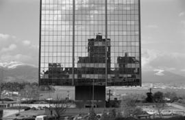 Buildings reflected in the West Coast Transmission Building, with a view of Coal Harbour
