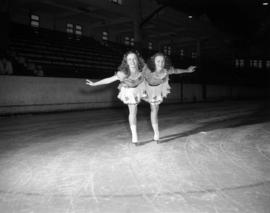 [Two women in costume skating together at the Rotary Ice Carnival]
