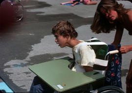 [Boy in wheelchair near swimming pool]