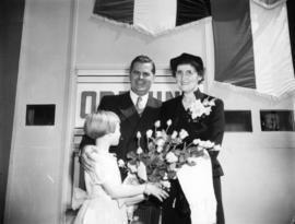 British Columbia Premier W.A.C. Bennett posing with woman and girl presenting flowers