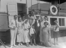 A group posing on the dock next to a boat